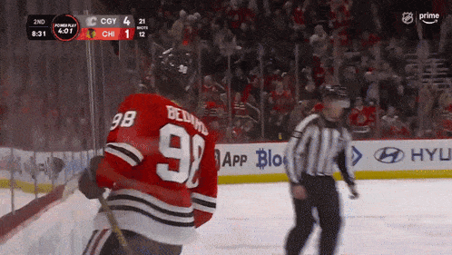 a hockey player with the number 98 on his jersey stands on the ice