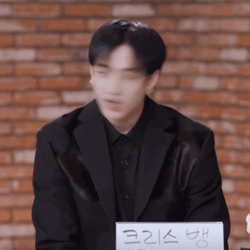 a blurry picture of a man in a suit with a sign in front of him that says ' korean '