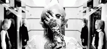 a woman with a tattoo on her hand is covering her face with her hand .