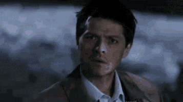 a man in a suit and tie is making a funny face .