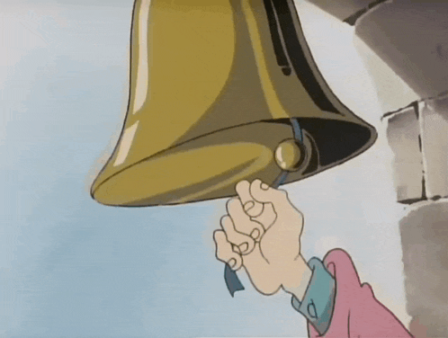 a hand is holding a bell with a blue ribbon around it