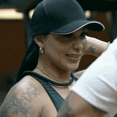 a woman wearing a black hat has a tattoo on her shoulder that says emilia