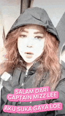 a woman wearing a hooded jacket and a mask on her face is making a funny face .