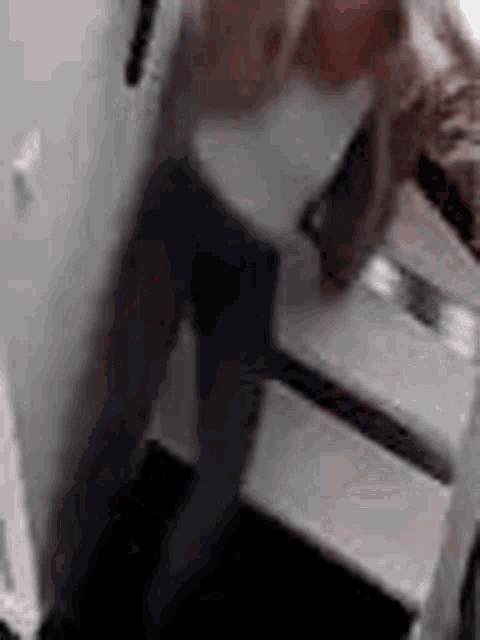 a blurry picture of a person standing on a staircase with a knife .