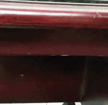 a close up of a red table with a few spots on it
