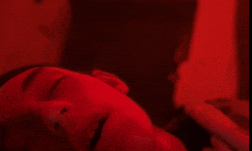 a close up of a person 's face with their eyes closed in a red light