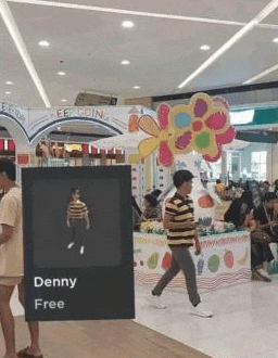 a man is holding a sign in a mall that says `` denny free '' .