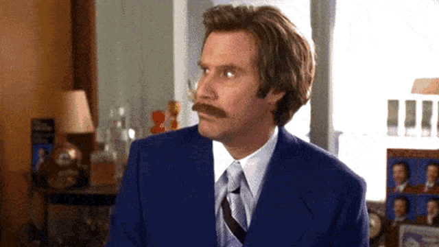 a man with a mustache wearing a suit and tie