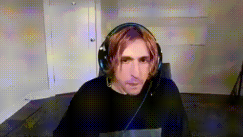a man with red hair is wearing headphones and a black shirt .