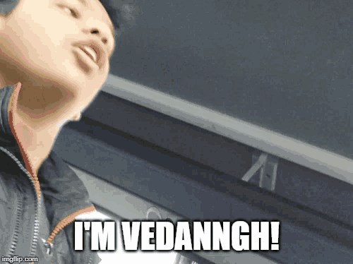 a man says i 'm vedanngh in front of a clock