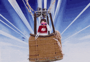 a boy in a hot air balloon looking through binoculars with the letter r on the shirt