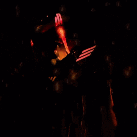 a person is standing in the dark with a red light coming out of their head .