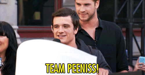 a man with a sign that says team peeniss on it