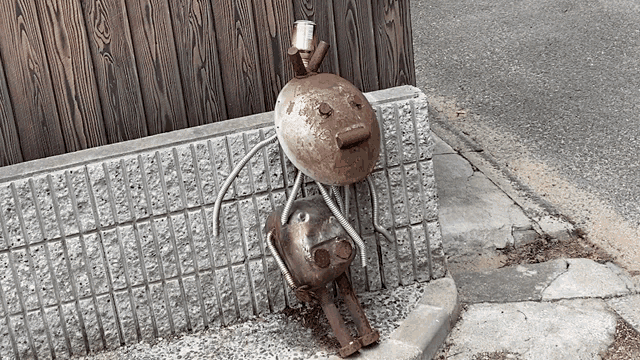 a sculpture of a man and a woman sitting on a sidewalk