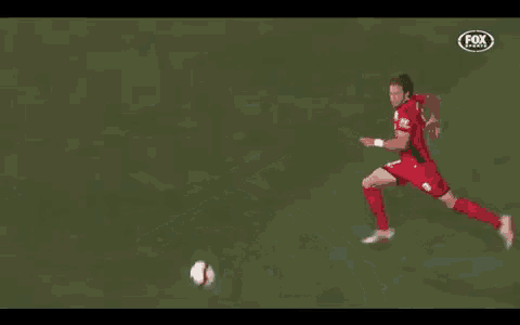 a soccer player in a red jersey with the number 11 on it is kicking the ball