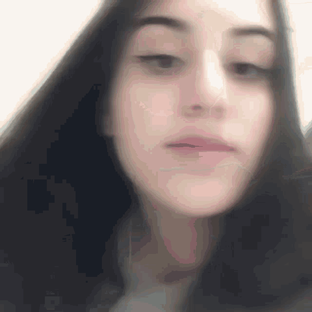 a blurry picture of a woman 's face with long hair .
