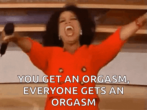 a woman in a red dress is holding a microphone and saying you get an orgasm everyone gets an orgasm .