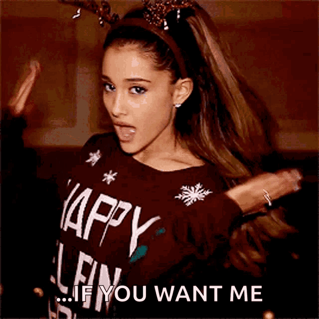 ariana grande is wearing a brown sweater that says happy christmas