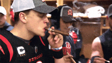 a man smoking a cigar in a bengals jersey