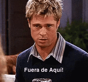 a man in a blue sweater has fuera de aqui written on his chest