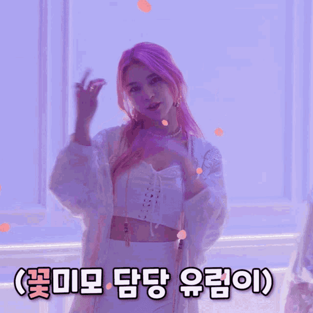 a woman with pink hair making a peace sign in front of a purple background