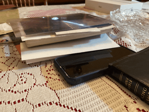 a stack of books including the holy bible sits on a table