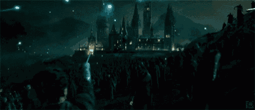 a crowd of people are gathered in front of a large castle at night