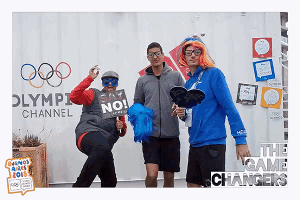 a group of people standing in front of a olympic channel sign
