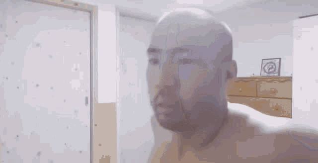 a blurred image of a man standing in a room with a door .