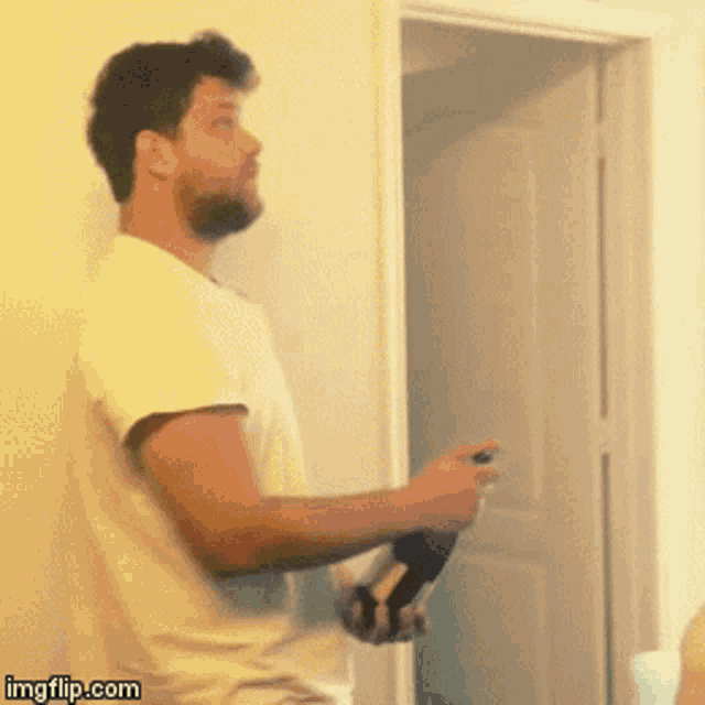a man in a white shirt is holding a bottle of wine in front of an open door