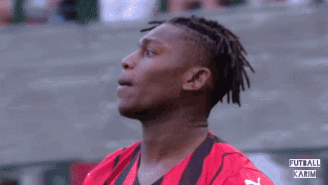 a soccer player is wearing a red and black jersey with the word futball karim on the bottom