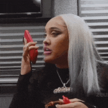a woman is talking on a cell phone while holding a cigar .