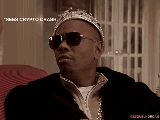 a man wearing a crown and sunglasses is sitting on a couch with the caption " sees crypto crash "