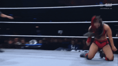a woman is kneeling down in a wrestling ring with the words los angeles on the bottom of the screen