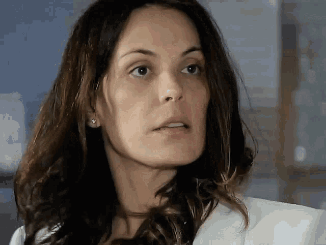 a close up of a woman 's face wearing a white coat