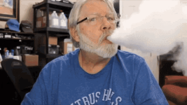 a man with a beard and glasses wearing a blue shirt that says citrus hill 's