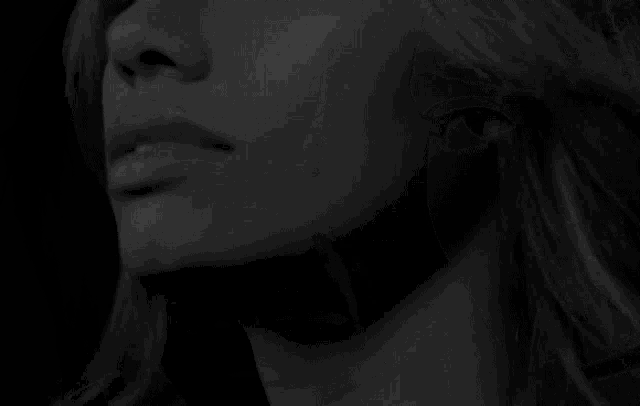 a black and white photo of a woman 's face with her mouth open