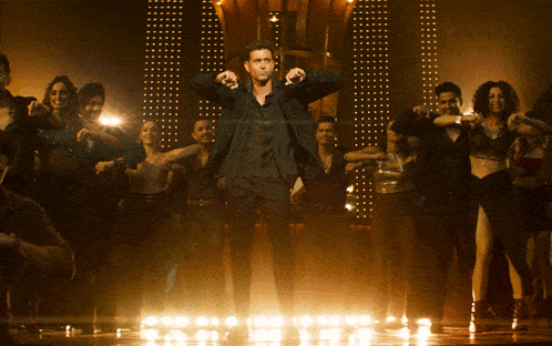 a man stands in front of a crowd with his arms up