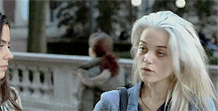 two women are standing next to each other on a bridge and one of them has white hair .
