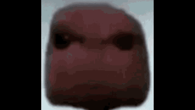 a close up of a person 's face with a blurred background and black eyes .