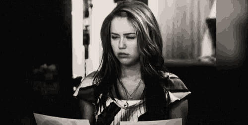 a black and white photo of a woman reading a book .