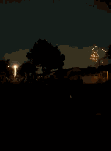 a fireworks display in a driveway with a garage in the background
