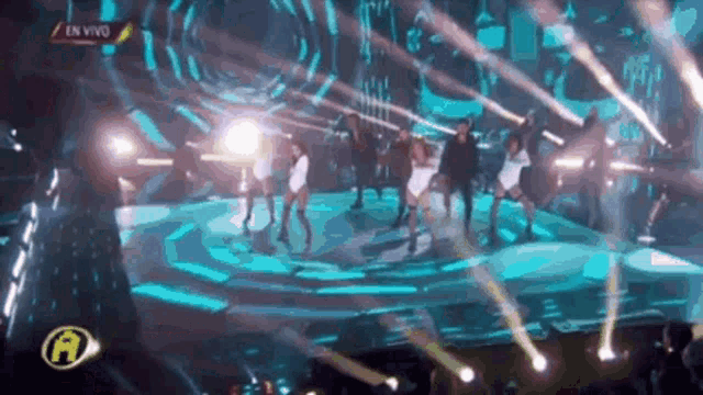 a group of people are dancing on a stage in a dark room .
