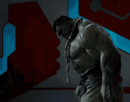 a hulk is standing in a room with a blue light behind him