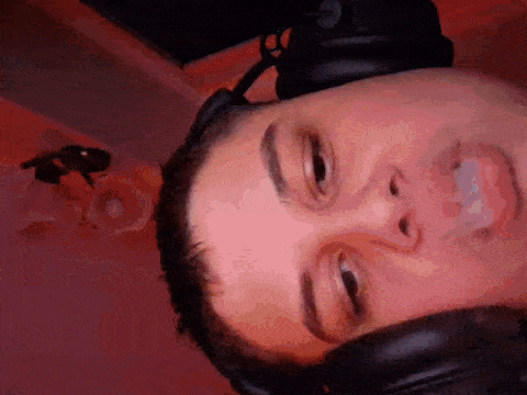 a close up of a man wearing headphones and making a face .