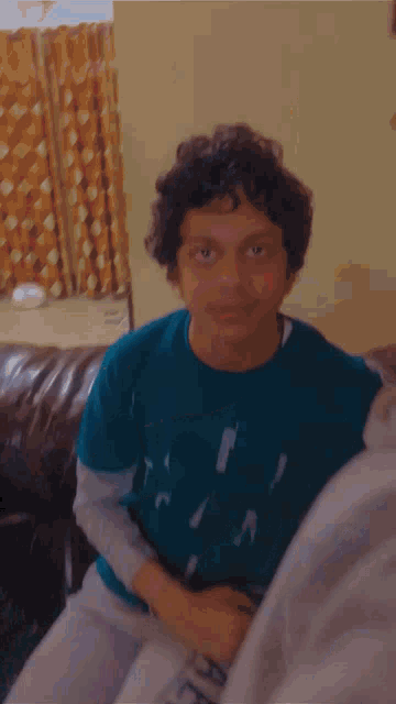 a young boy with curly hair is being held by a woman