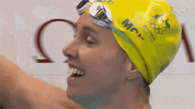 a woman wearing a yellow swim cap that says mcv
