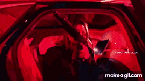 a man is dancing in front of a drum set in a room with red lights .