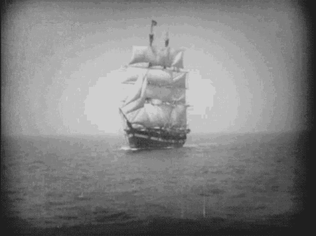 a black and white photo of a sailboat in the ocean .