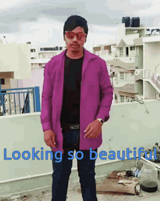 a man in a purple jacket is standing on a balcony with the words " looking so beautiful " written below him
